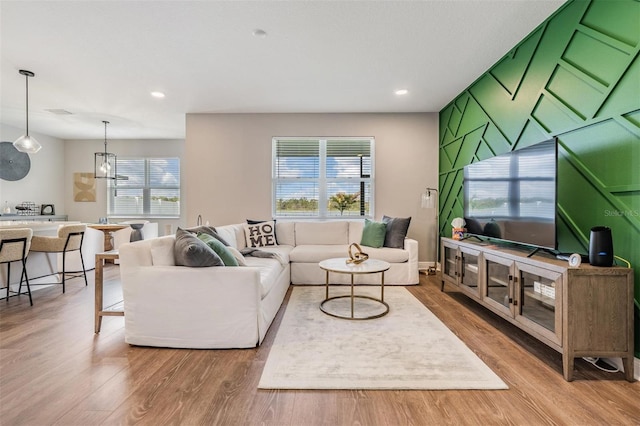 living area with baseboards, wood finished floors, and recessed lighting