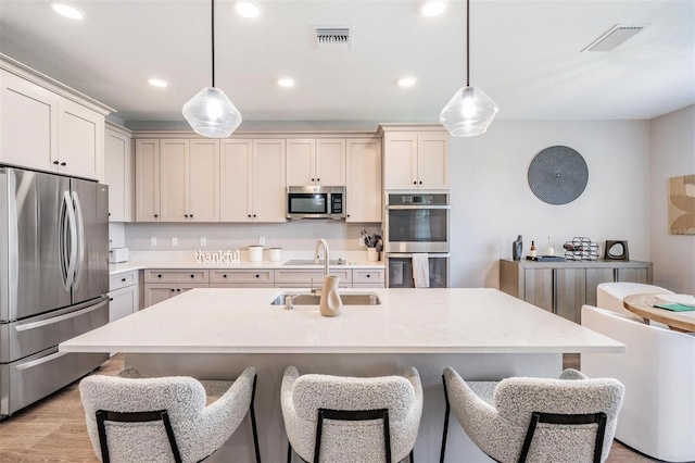 kitchen with stainless steel appliances, hanging light fixtures, and light countertops