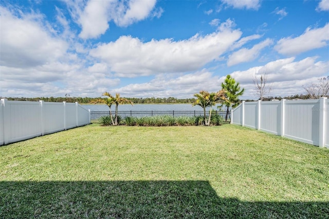 view of yard with a water view and a fenced backyard