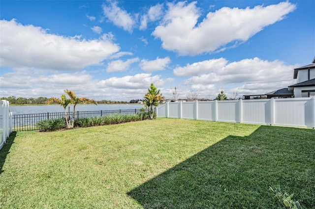 view of yard with a water view and a fenced backyard