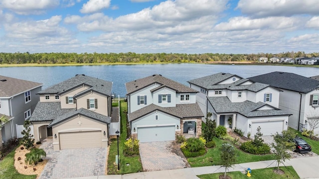 view of front of home featuring a residential view, a water view, driveway, and stucco siding