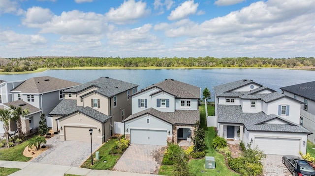 view of front of house featuring a residential view, decorative driveway, and a water view