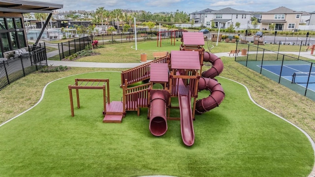 communal playground with a tennis court, a residential view, fence, and a lawn