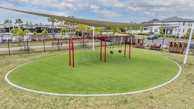 view of home's community featuring a yard, a residential view, playground community, and fence