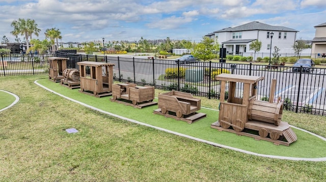 view of jungle gym featuring a yard, a residential view, and fence