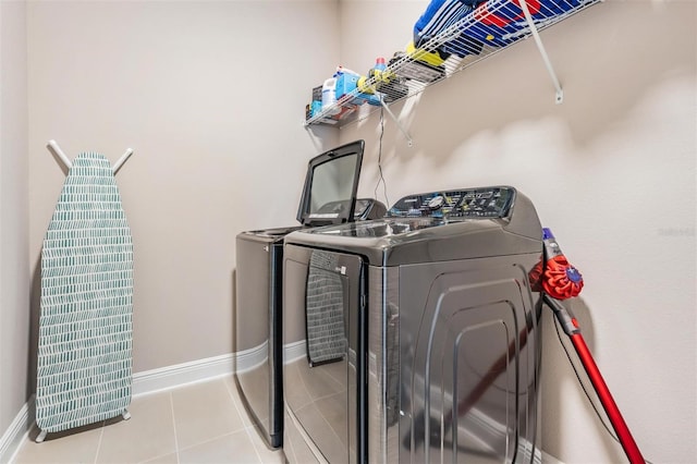 laundry room with laundry area, baseboards, separate washer and dryer, and light tile patterned flooring