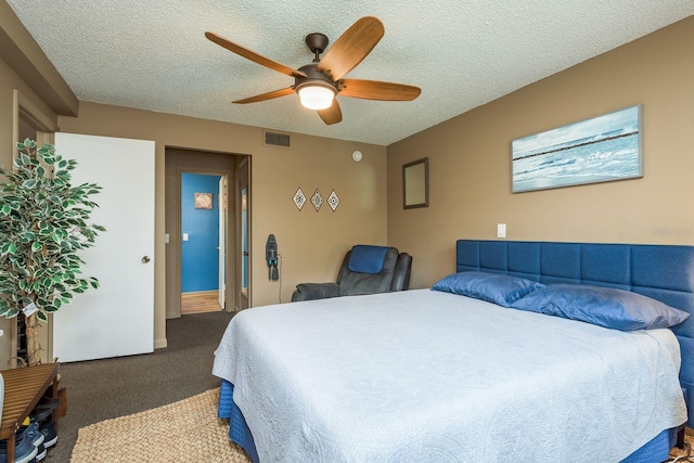 bedroom featuring a textured ceiling, dark colored carpet, ceiling fan, and visible vents