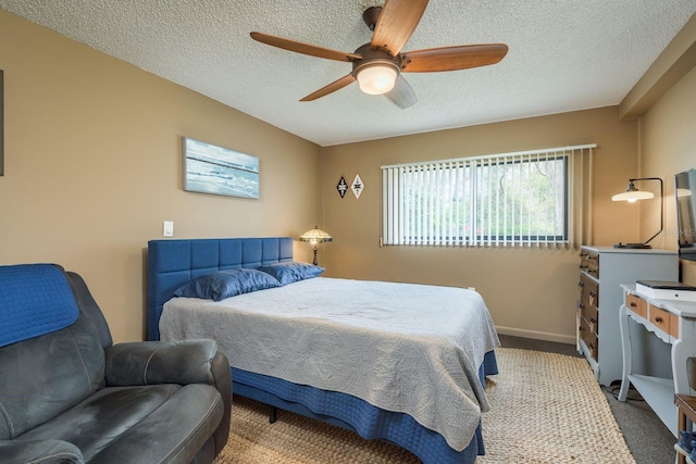 carpeted bedroom with a textured ceiling, baseboards, and a ceiling fan