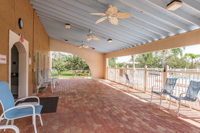 view of patio featuring a ceiling fan and fence