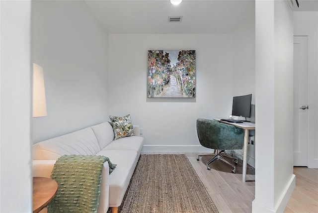 office with light wood-type flooring, baseboards, and visible vents