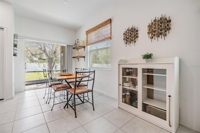 dining space featuring light tile patterned flooring and baseboards