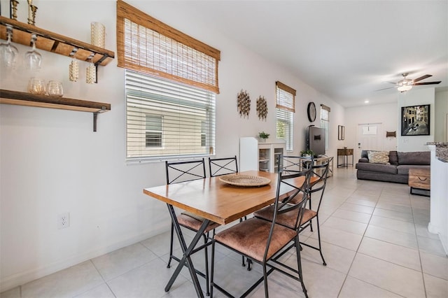 dining space with light tile patterned floors, ceiling fan, and baseboards