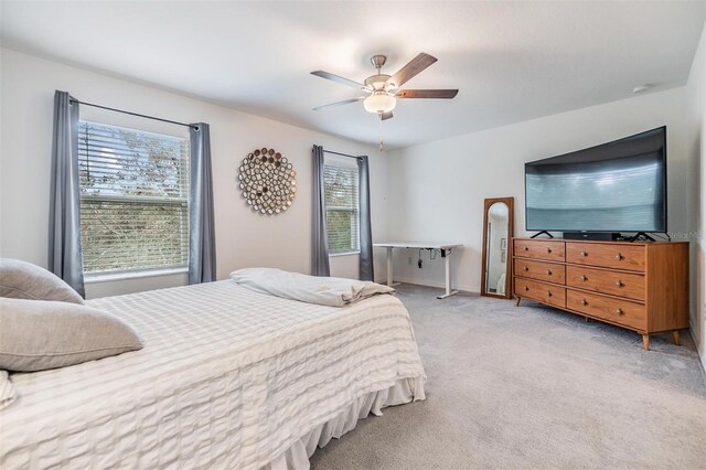 bedroom featuring light carpet, ceiling fan, and baseboards