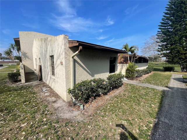 view of home's exterior featuring a lawn and stucco siding