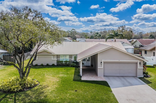 ranch-style home with stucco siding, concrete driveway, an attached garage, a front yard, and metal roof