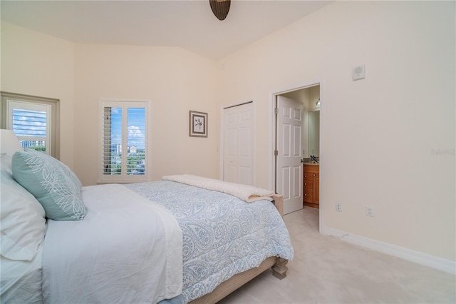 bedroom featuring light carpet, baseboards, connected bathroom, and lofted ceiling