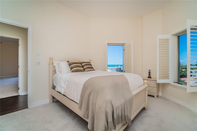 bedroom with light colored carpet and baseboards