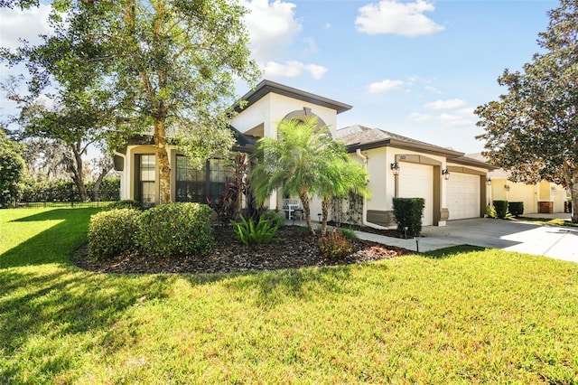 view of front facade with a garage, driveway, a front lawn, and stucco siding