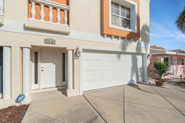 exterior space featuring a garage, concrete driveway, and stucco siding