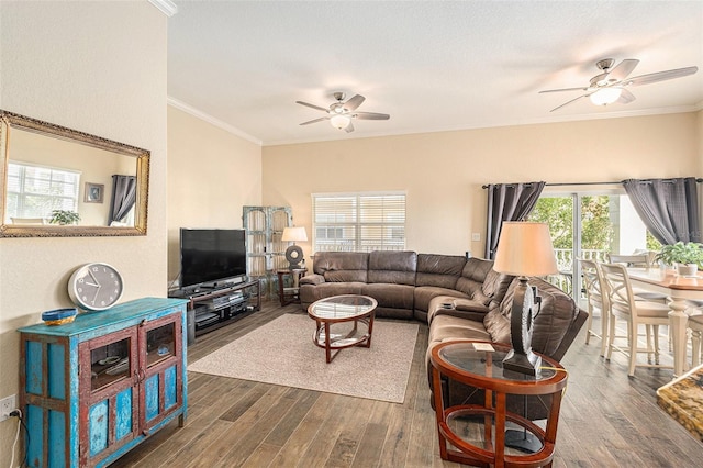 living area with ornamental molding, dark wood-style flooring, and a ceiling fan