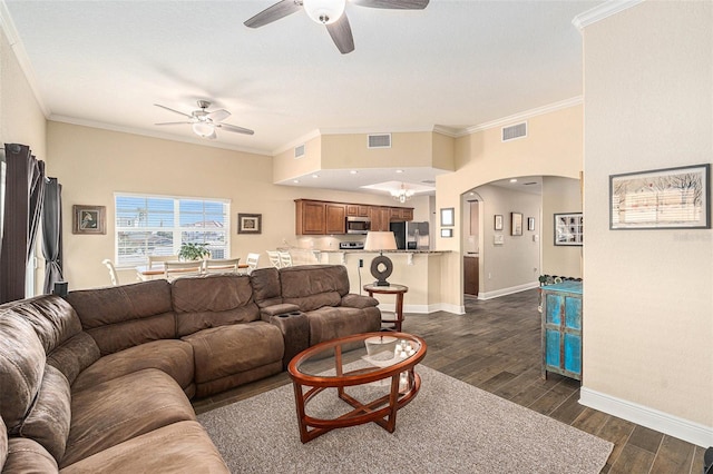 living room featuring dark wood-style floors, visible vents, arched walkways, and ornamental molding