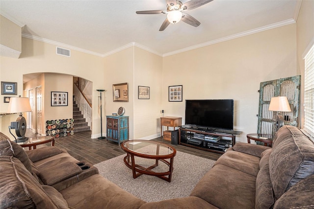 living room featuring visible vents, arched walkways, stairway, ornamental molding, and wood finished floors