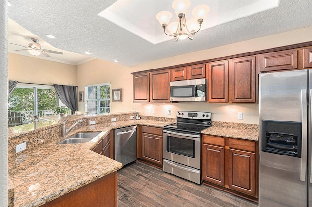 kitchen with light stone countertops, dark wood-type flooring, stainless steel appliances, and a sink