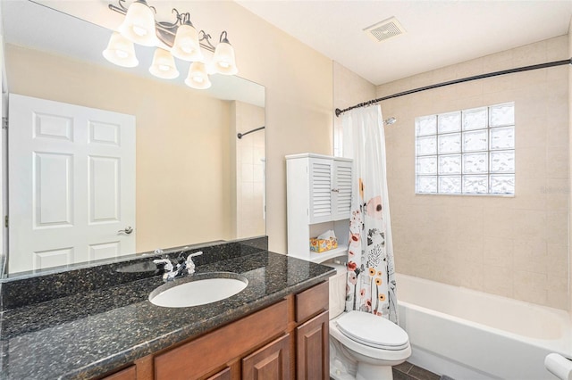bathroom featuring toilet, vanity, shower / bath combo with shower curtain, and visible vents