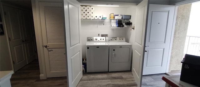 laundry room with laundry area, washing machine and dryer, and dark wood-style floors