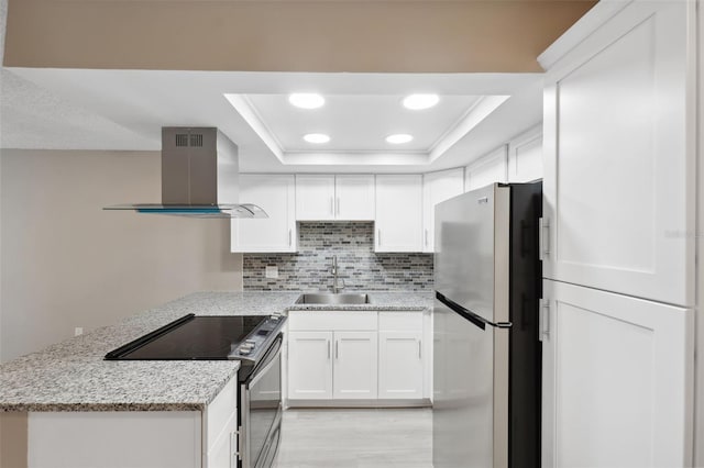 kitchen featuring island range hood, white cabinets, electric range oven, and freestanding refrigerator