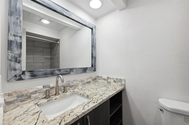 bathroom featuring toilet, a shower, and vanity