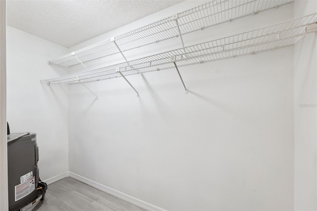 walk in closet with wood finished floors