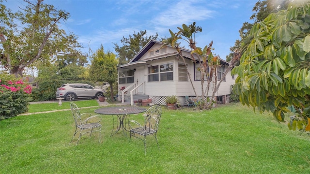 rear view of property featuring a lawn