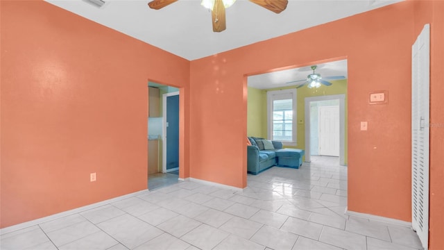 unfurnished room with light tile patterned floors, baseboards, and ceiling fan