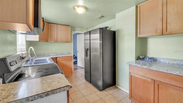 kitchen with a sink, light brown cabinets, light countertops, stainless steel appliances, and visible vents