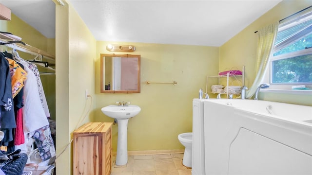 full bath with toilet, baseboards, a sink, and a bathtub