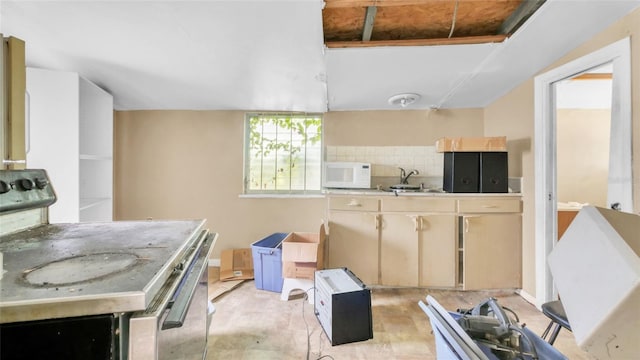 kitchen featuring backsplash, range with electric cooktop, light countertops, white microwave, and light brown cabinets