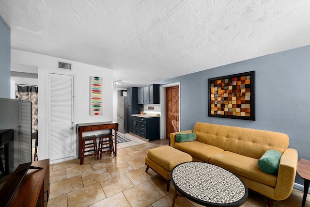 living room with visible vents and a textured ceiling