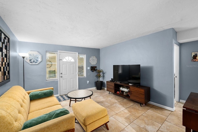 living area with a textured ceiling, baseboards, and light tile patterned floors