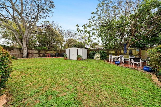 view of yard with an outbuilding, a shed, and a fenced backyard