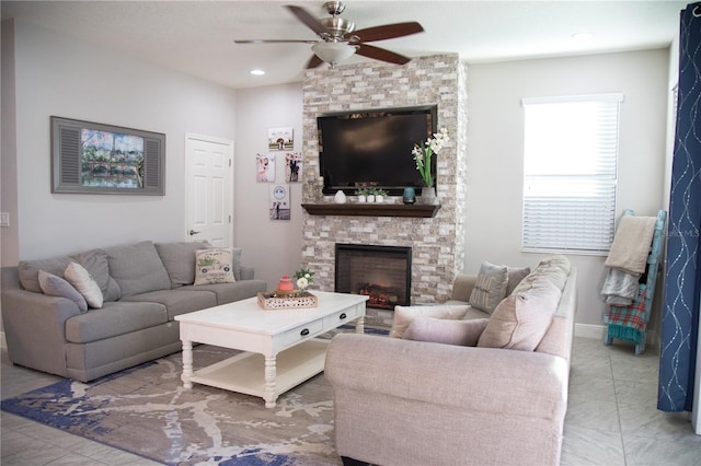 living area featuring ceiling fan, a stone fireplace, baseboards, and recessed lighting