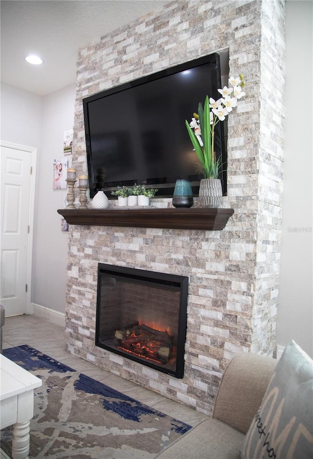 interior details with a stone fireplace and baseboards