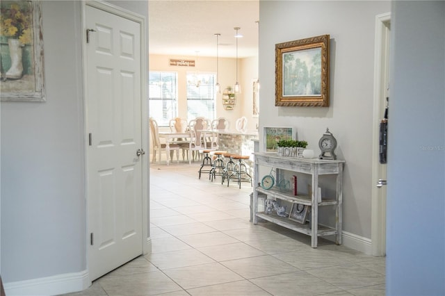 hallway with light tile patterned floors and baseboards