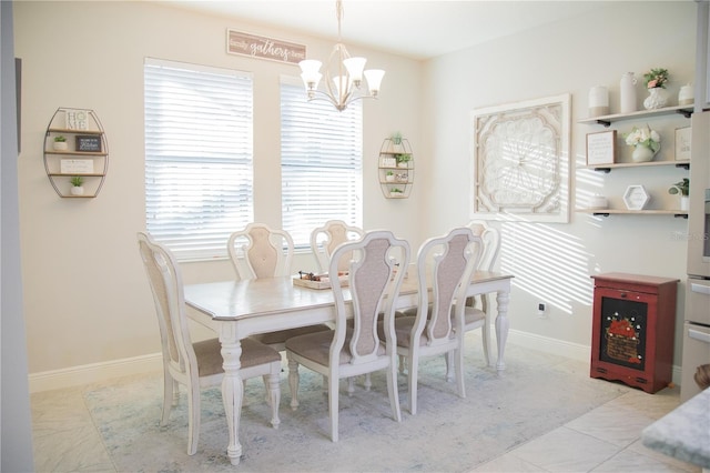 dining space with baseboards and a notable chandelier