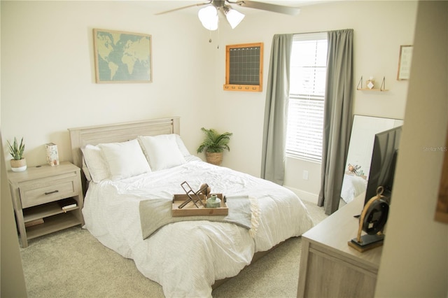 bedroom featuring light carpet, multiple windows, and a ceiling fan