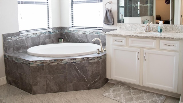 bathroom with a shower, a garden tub, and vanity