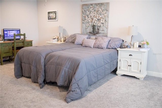 bedroom with baseboards and light colored carpet