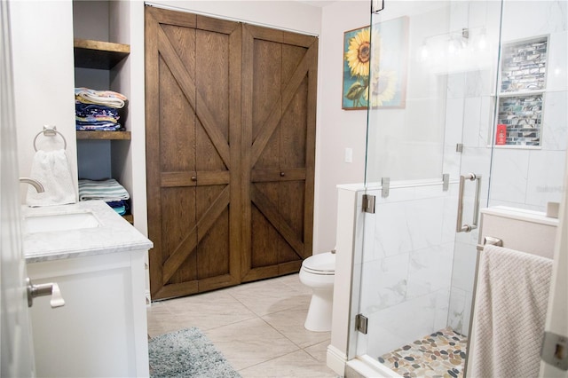 bathroom featuring toilet, a stall shower, and vanity