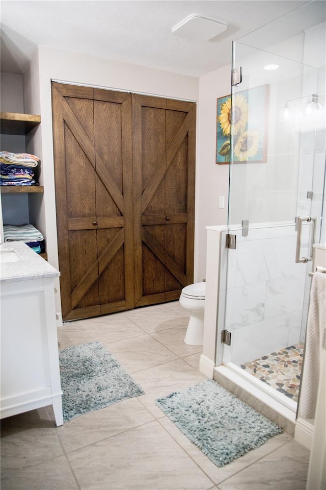 full bath featuring a stall shower, vanity, and toilet