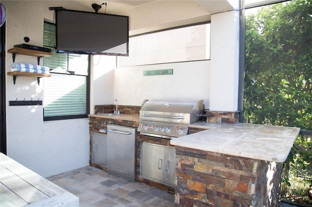 view of patio with a sink, an outdoor kitchen, and a grill